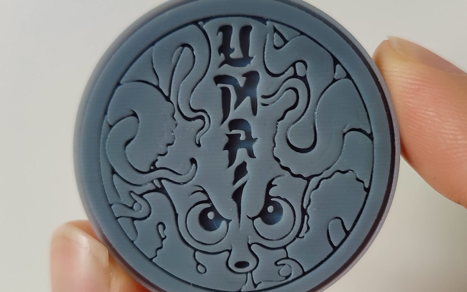 3D print van een ronde coin met gedetailleerd logo, gemaakt via een lokale 3D printing service.