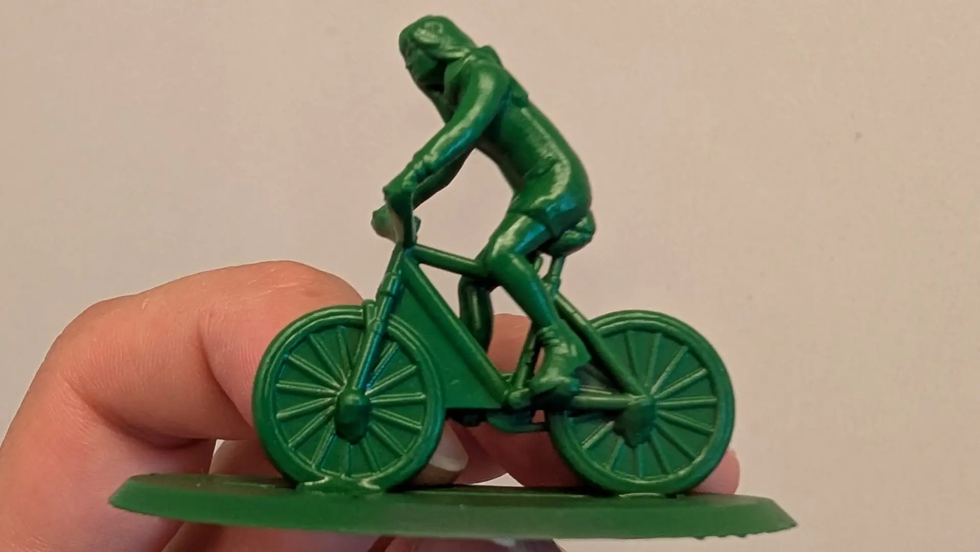 Groen miniatuurfiguur van een vrouw op een fiets. Gemaakt met resin 3D printers.